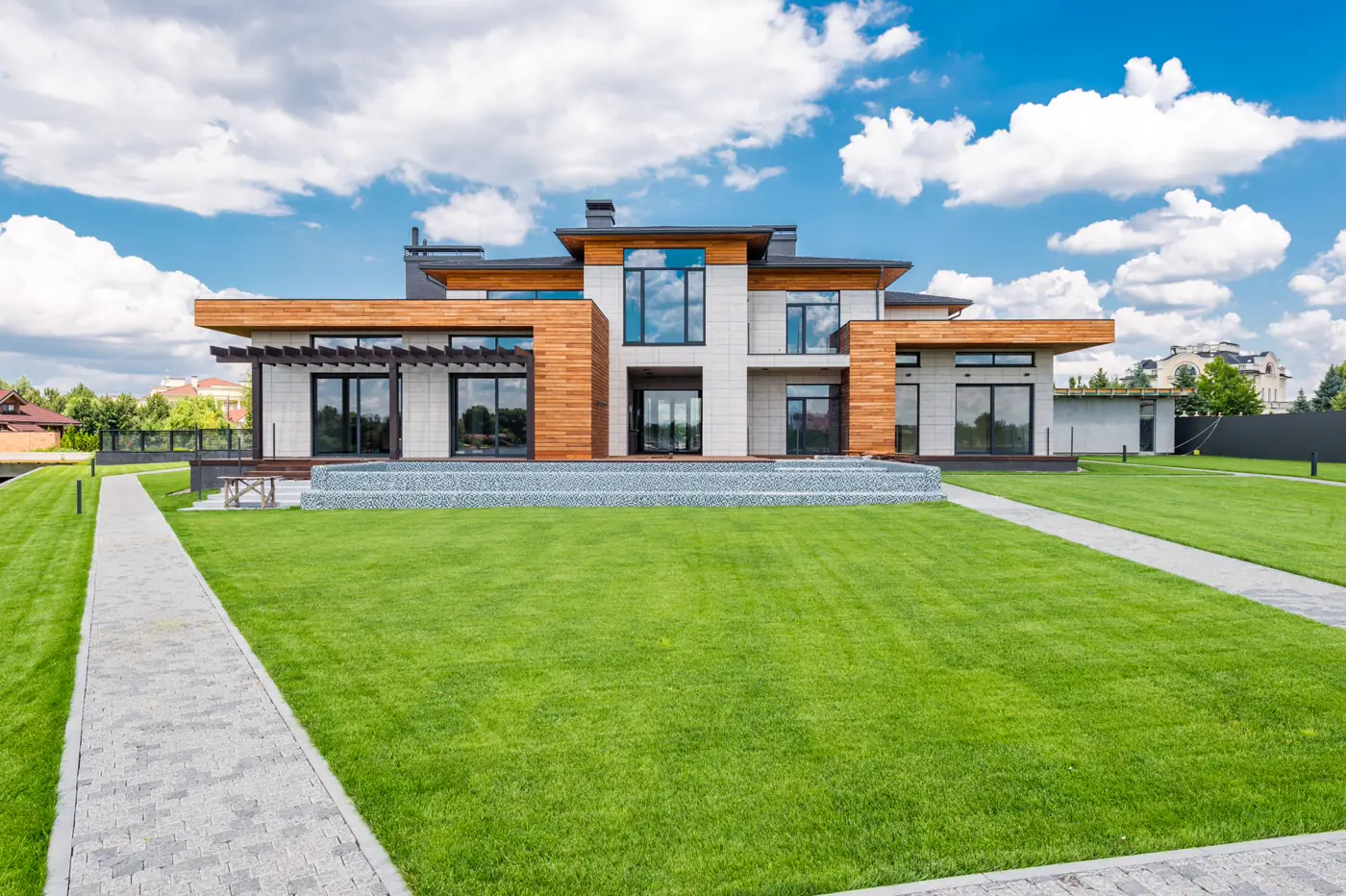 A modern home with large windows and a manicured lawn